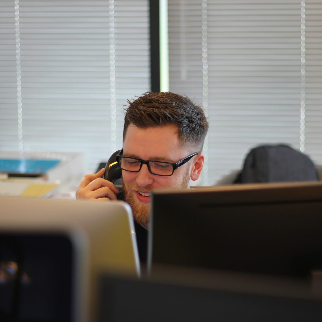 Person on a phone call while looking at a computer screen